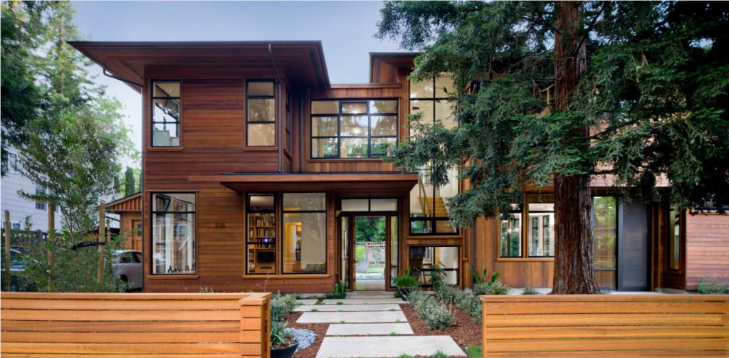 Street elevation of the Palo Alto 3 House, its cedar-clad forms broken into smaller traditional volumes behind a slatted fence.